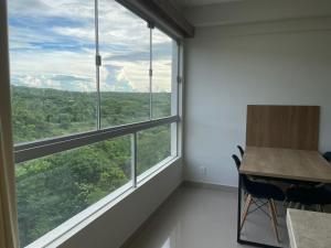 Zimmer mit einem Schreibtisch und einem großen Fenster in der Unterkunft Park Veredas, Rio Quente , com vista para a montanha in Rio Quente