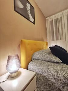 a bedroom with a bed and a lamp on a night stand at Affaire - Ideal pour séjour 7-14-28 nuits in Noisy-le-Grand