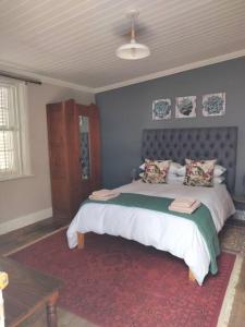 a bedroom with a large bed with a red rug at Via the Grapevine 3 bedroom house private parking in Colesberg