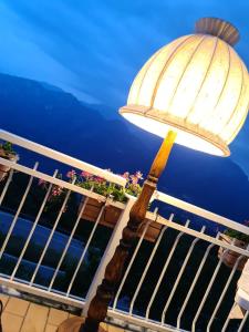 a lamp on a balcony with a view of the ocean at LOCANDA MIRABEAU in Bellagio