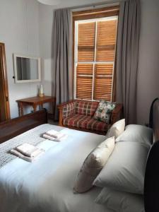 a bedroom with a large white bed and a couch at Via the Grapevine 3 bedroom house private parking in Colesberg