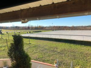 a view of a tennis court in a field at Gite-Grand studio contemporain proche Toulouse dans domaine Equestre in Bouloc