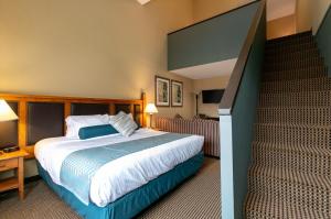 Habitación de hotel con cama y escalera en Blackcomb Lodge, en Whistler