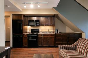 a kitchen with wooden cabinets and a stove top oven at Blackcomb Lodge in Whistler