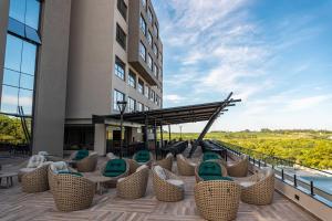 eine Hotelterrasse mit Stühlen und ein Gebäude in der Unterkunft Complexo Eco Cataratas Resort in Foz do Iguaçu