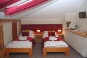 a room with two beds with towels on them at Pensjonat Dworek Polski in Chojno