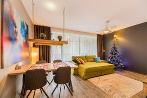 a living room with a christmas tree and a couch at MAIO Studio Silver Mountain Poiana Brasov in Poiana Brasov