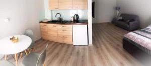 um quarto com uma cozinha, uma mesa e uma cama em Apartament Konin Prestige em Konin