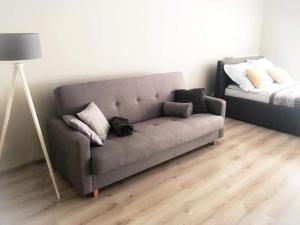 um sofá com almofadas na sala de estar em Apartament Konin Prestige em Konin