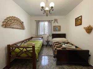 a bedroom with two beds and a chandelier at Casa Rural Los Caleros in Fondón