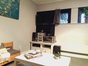 uma sala de estar com uma mesa e um micro-ondas em Vakantiehuis aan het Bos - langs de Tulpenroute! em Bant