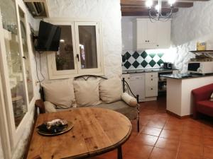 sala de estar con mesa y sofá en el Sotanillo en Valverde de la Vera