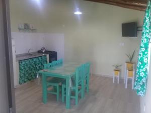 a dining room with a green table and chairs at Cabañas Borboletas in San Rafael