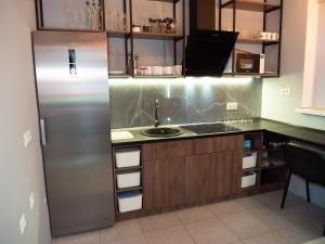 een keuken met een roestvrijstalen koelkast en een wastafel bij D - Hostel in Irpin'