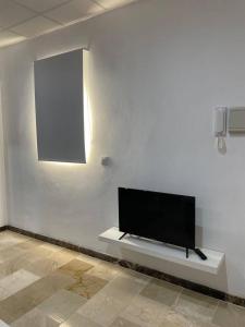 einen Flachbild-TV auf einer weißen Wand in der Unterkunft Apartamento en Olula del Río in Olula del Río