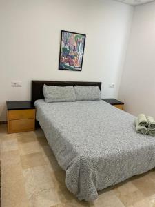 ein Schlafzimmer mit einem Bett und zwei Nachttischen in der Unterkunft Apartamento en Olula del Río in Olula del Río