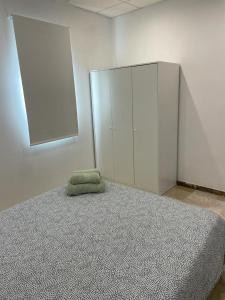 ein Schlafzimmer mit einem Bett mit einem grünen Kissen darauf in der Unterkunft Apartamento en Olula del Río in Olula del Río