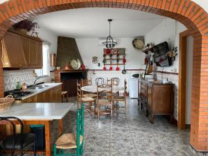una cocina con un arco con mesa y sillas en Casa Rural Los Caleros, en Fondón