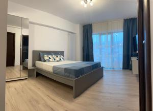 1 dormitorio con cama y ventana grande en New Studio, en Piteşti