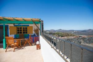 une maison avec une table et des chaises sur un balcon dans l'établissement Casa La Geria, à La Asomada