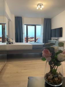 - une chambre avec un lit et un vase de fleurs sur une table dans l'établissement New Studio, à Piteşti