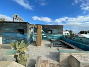 a house with a wave painted on the side of it at ITY House in Playa Honda