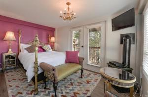 a bedroom with a king sized bed and a chandelier at Raven Point Inn in Ladysmith