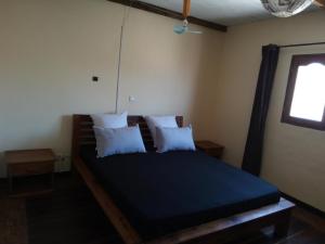 a bedroom with a bed with blue sheets and pillows at Villa Nature in Toliara