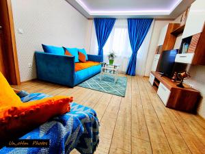 a living room with a blue couch and a television at Boulevard Flat in Alba Iulia