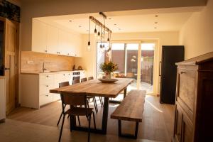 a kitchen with a wooden table and chairs in it at Vakantiewoning Dorp-28 in Hollebeke