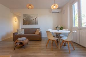 a living room with a couch and a table and chairs at Mosse Leopolda Apartment by Mamo Florence in Florence