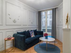 een woonkamer met een blauwe bank en een tafel bij The Blue Pearl in Parijs
