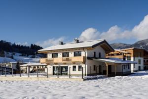 uma casa na neve em frente a uma montanha em Appartement Gaisbergblick em Kirchberg in Tirol