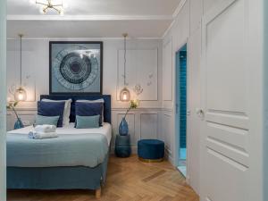 een slaapkamer met een bed met blauwe kussens bij The Blue Pearl in Parijs