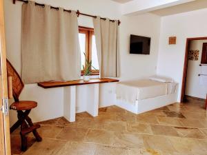 a bedroom with a bed and a desk and a window at Villa Pinolo by Kabana in Prea