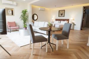 Una sala de estar con una cama, una mesa y sillas. en Malfakum Al Diriyah, en Riad