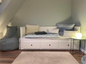 ein weißes Sofa mit Kissen darauf im Zimmer in der Unterkunft Bi uns too Huus in Wilhelmshaven