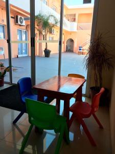 een houten tafel en stoelen in een kamer met een raam bij Hotel Danae in Piriápolis