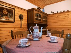 una sala da pranzo con tavolo, vaso e tazze di Alp House a Bohinjska Bela