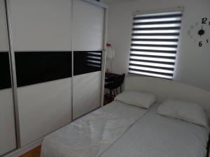 a bedroom with a bed and a sliding glass door at Apartman Pivasevic in Sarajevo