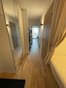 a hallway of a room with a bed and a mirror at APPARTEMENT STATION LA JOUE DU LOUP PIED DES PISTES in Le Dévoluy