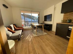 een woonkamer met een bank en een tafel bij APPARTEMENT STATION LA JOUE DU LOUP PIED DES PISTES in Le Dévoluy