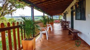 a porch with chairs and tables and a fence at El Portal De Don Luis in Guadalupe