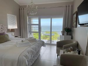 a bedroom with a bed and a view of the ocean at Vermont Hermanus - views, sunny, right on the sea in Hermanus