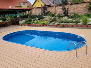 uma grande piscina azul num quintal em Penzion U Kostela em Kuželov