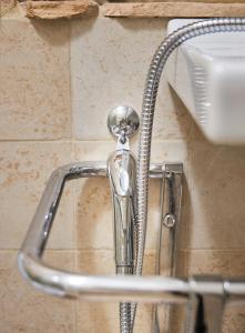 un rubinetto della doccia su una parete in bagno di Taverna del Colle, tra relax e comfort a Pescara