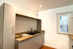 uma cozinha com um balcão com um lavatório e um frigorífico em BNB RENTING Atypical condo in rue Fourmillière em Antibes