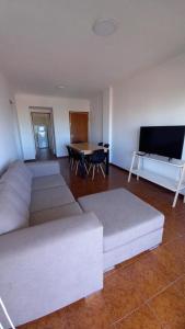 a living room with a couch and a table at Departamentos 3 Ambientes Cochera Punta Mogotes in Mar del Plata