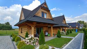 una casa di tronchi con tetto di paglia di Domki Białka & Apartamenty a Białka