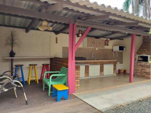 un patio con un bar con mesas y sillas coloridas en Pousada Caminhos da Praia, en Penha